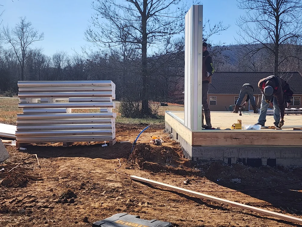 Crew staging first wall panels on framed deck
